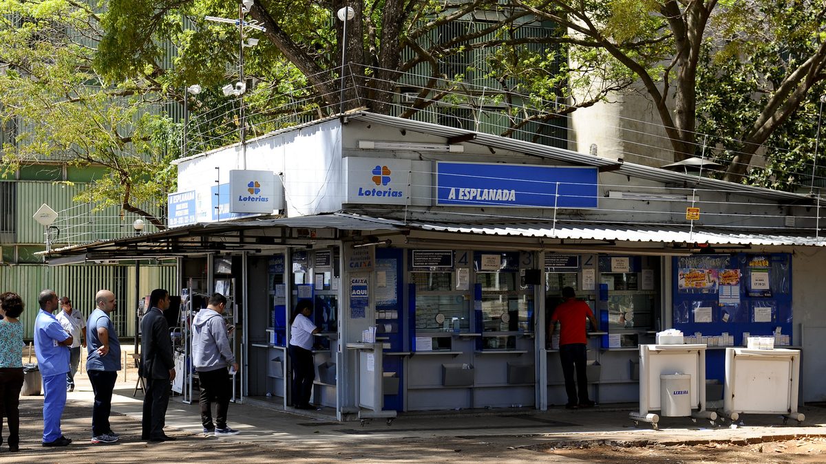 Pessoas em fila diante de casa lotérica da Caixa