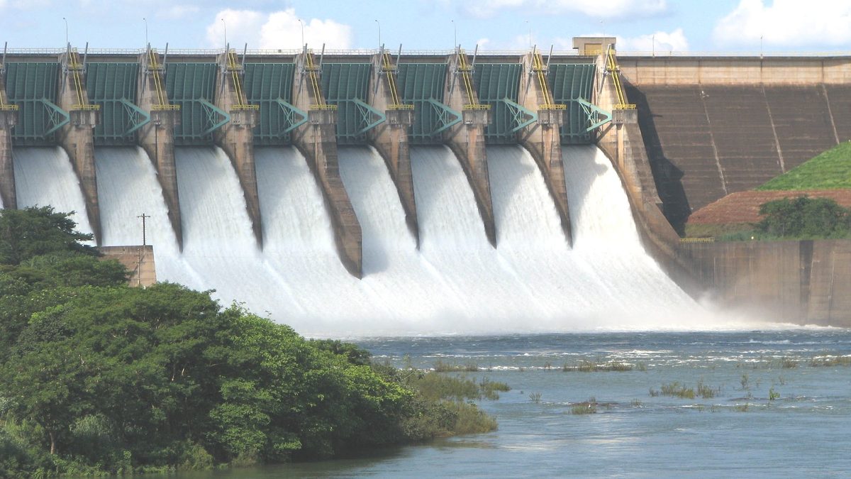 Vertedouro de usina hidrelétrica com as comportas abertas e a água correndo para o rio