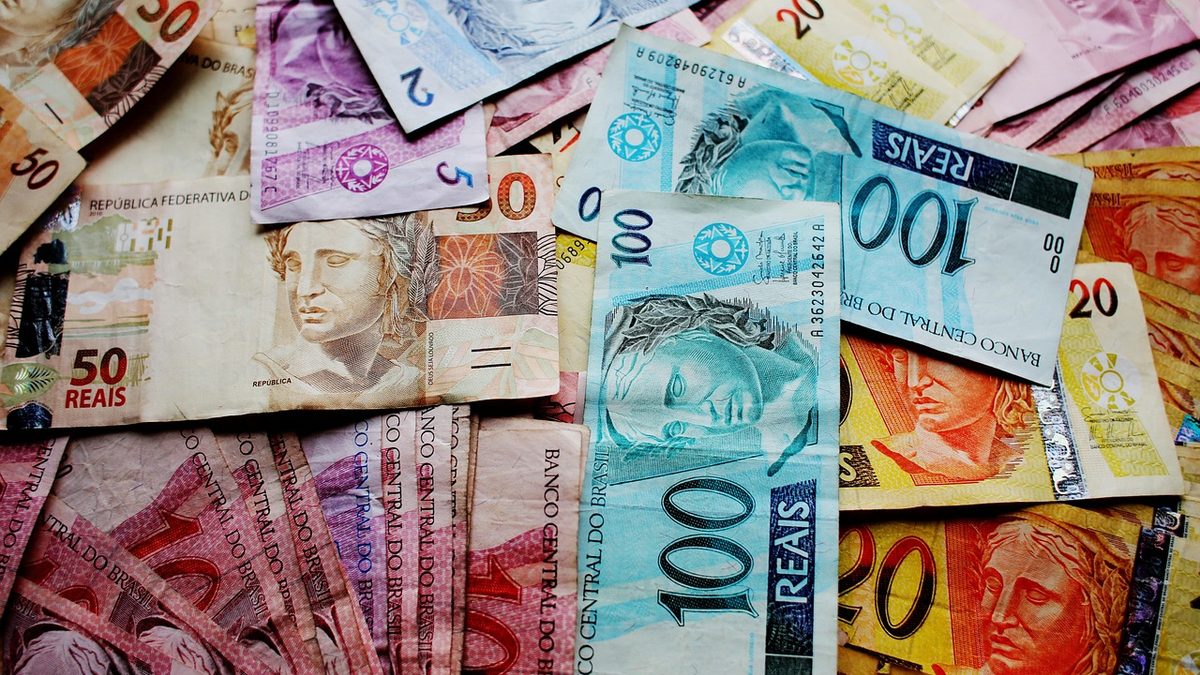 Cédulas de real de vários valores espalhadas sobre a mesa