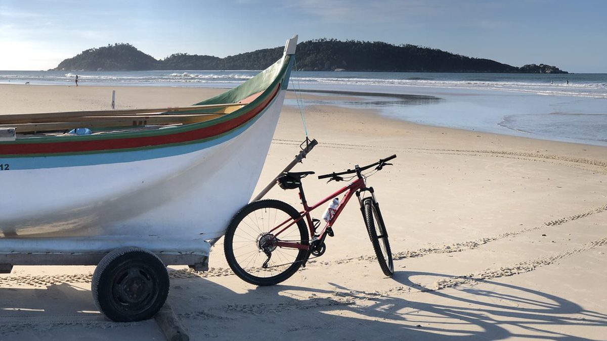 Barco de pesca e bicicleta na areia da Praia do Campeche, em Florianópolis